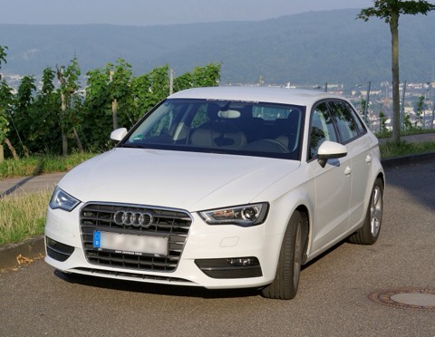 Audi A3 Sportback 8V blanco de tres cuartos delantero en una carretera secundaria entre viñedos