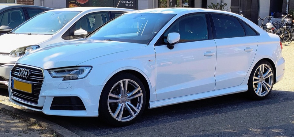 Audi A3 Limousine 8V blanco con acabado S line, de tres cuartos delantero en una calle