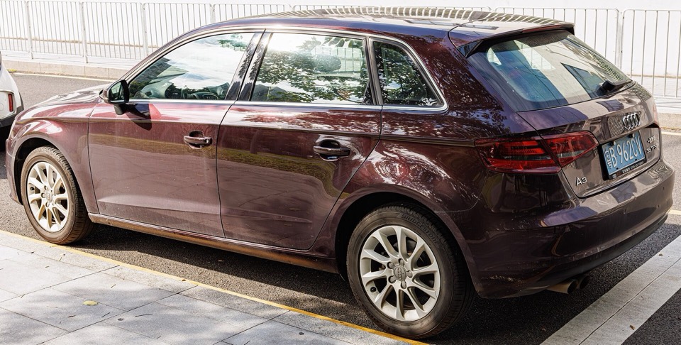 Audi A3 Sportback 8V granate aparcado en una calle, con el uso propio de un coche de segunda mano