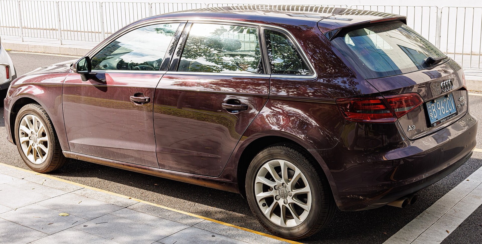Audi A3 Sportback 8V granate aparcado en una calle, con el uso propio de un coche de segunda mano