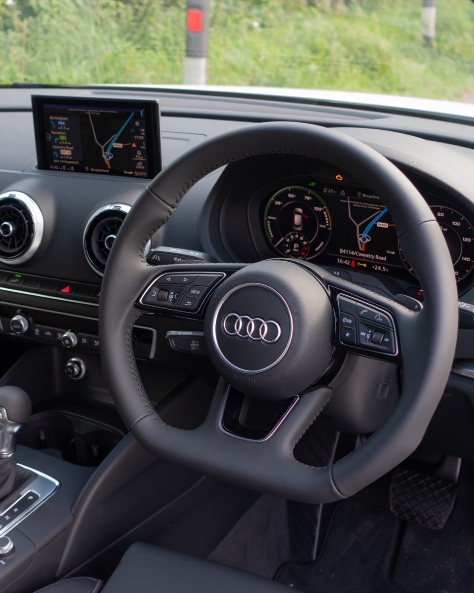 Puesto de conducción de un Audi A3 8V con el volante, el cuadro digital y la pantalla de navegación en marcha