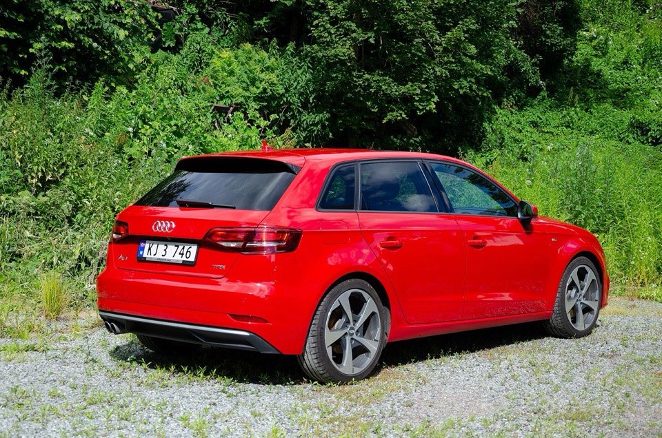 Audi A3 Sportback 8V rojo de tres cuartos trasero en un camino rodeado de vegetación