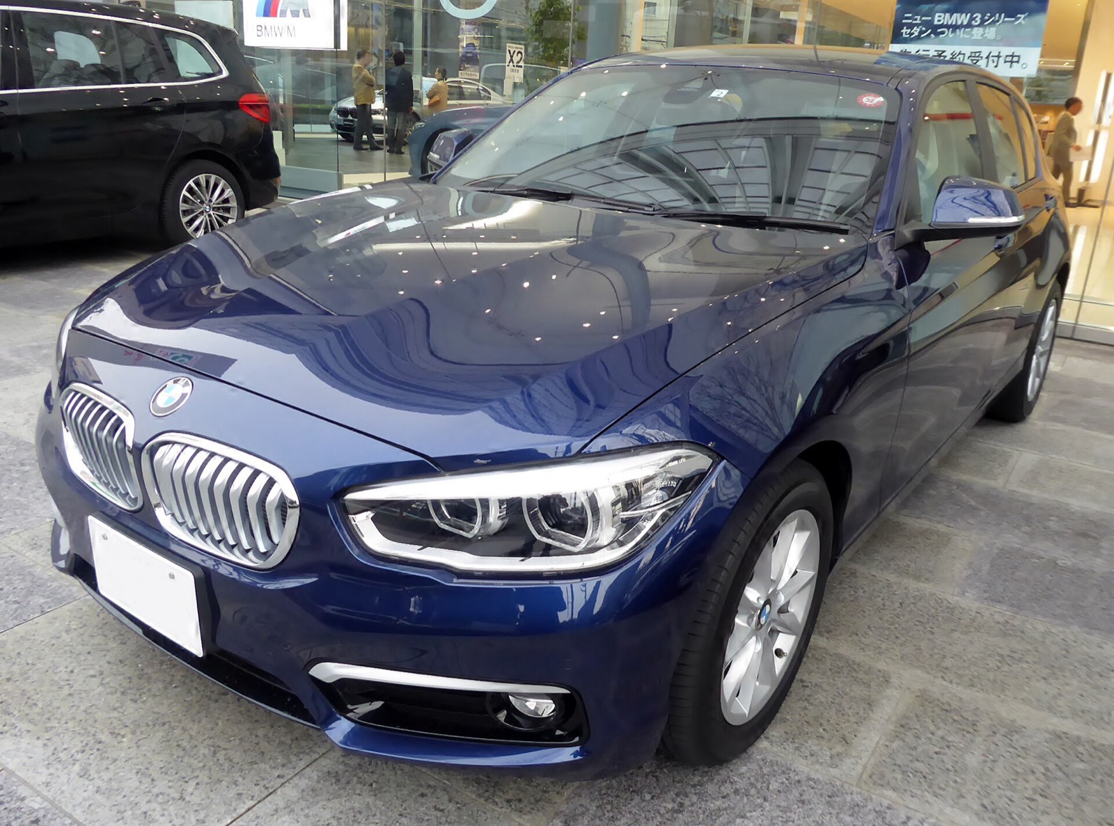 BMW Serie 1 F20 azul oscuro de tres cuartos delantero en la exposición de un concesionario
