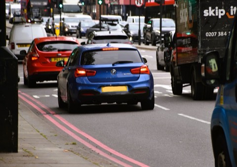 BMW Serie 1 F20 azul en un atasco urbano de Londres, entre furgonetas y otros coches