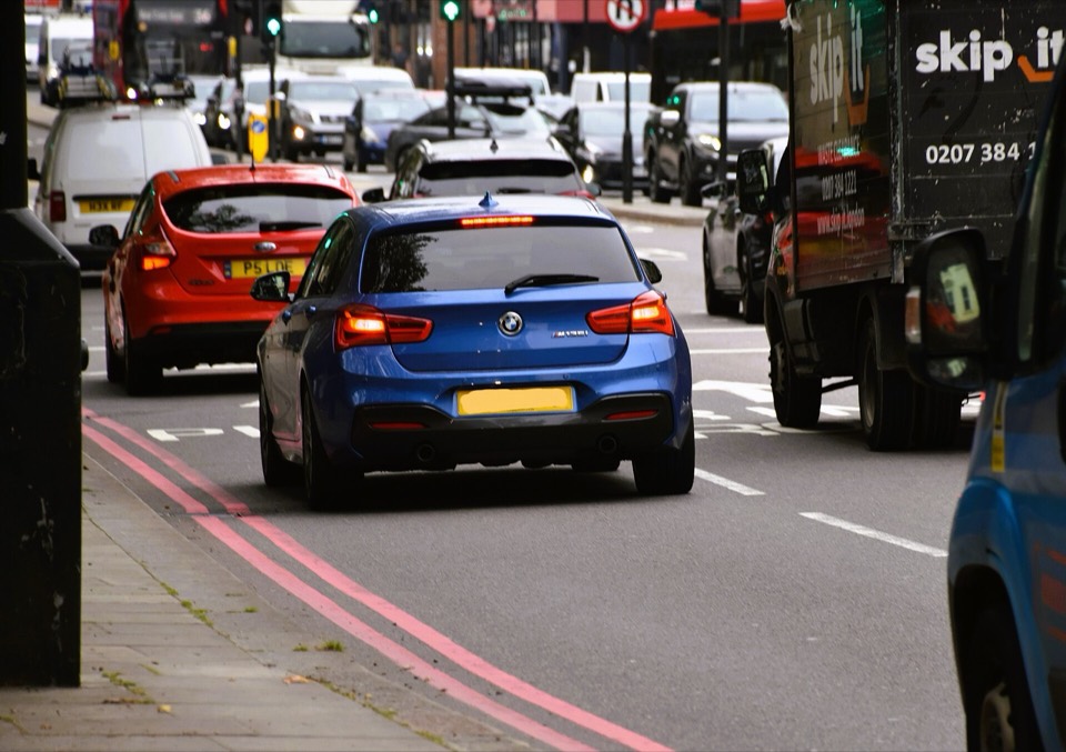 BMW Serie 1 F20 azul en un atasco urbano de Londres, entre furgonetas y otros coches