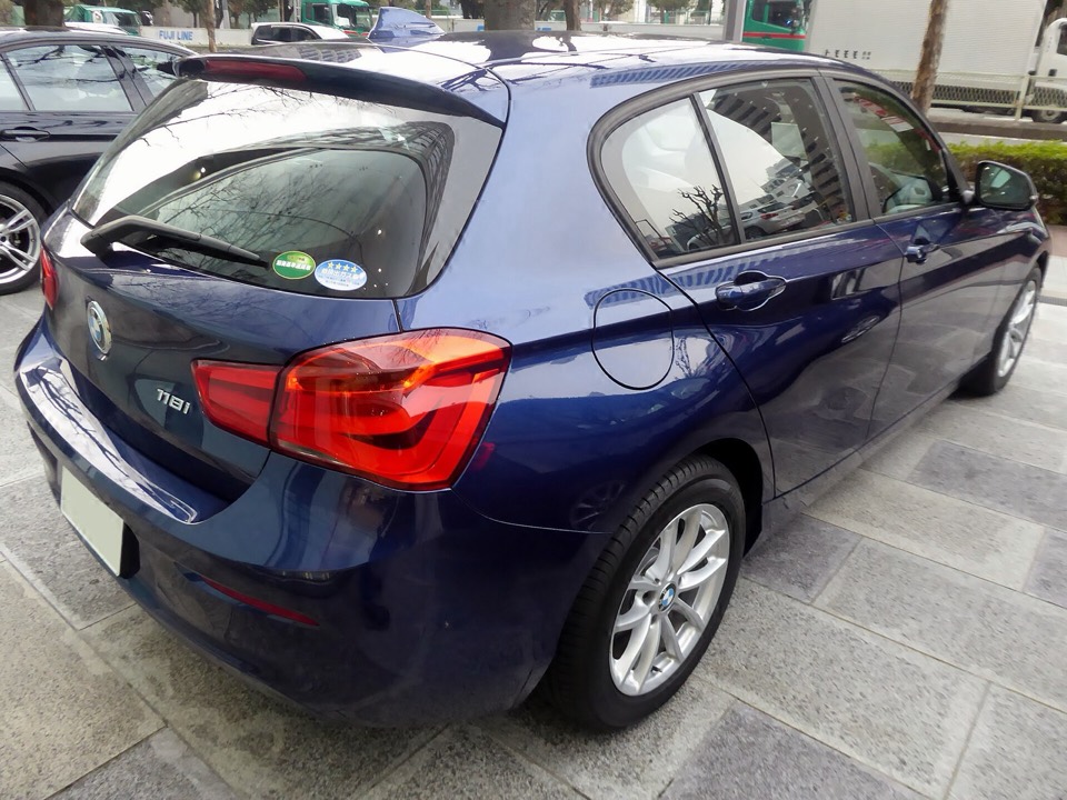 BMW Serie 1 F20 azul de tres cuartos trasero aparcado sobre pavimento adoquinado
