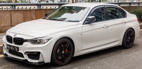 BMW Serie 3 F30 blanco con acabado M Sport, llantas negras y pinzas de freno rojas, de tres cuartos delantero