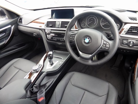 Puesto de conducción de un BMW Serie 3 F30: volante, cuadro de instrumentos analógico y pantalla central