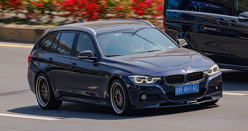 BMW Serie 3 F30 Touring azul oscuro circulando por una avenida