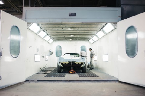 Coche dentro de una cabina de pintura de un taller de carrocería
