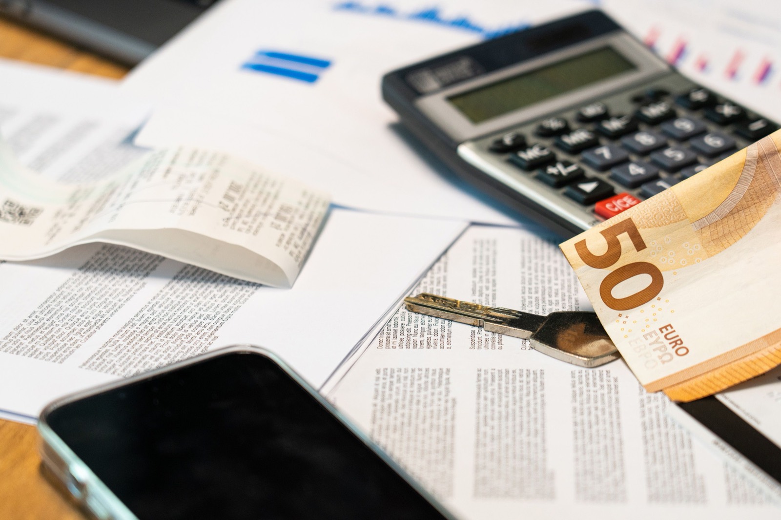Calculadora sobre unos documentos junto a un billete de cincuenta euros