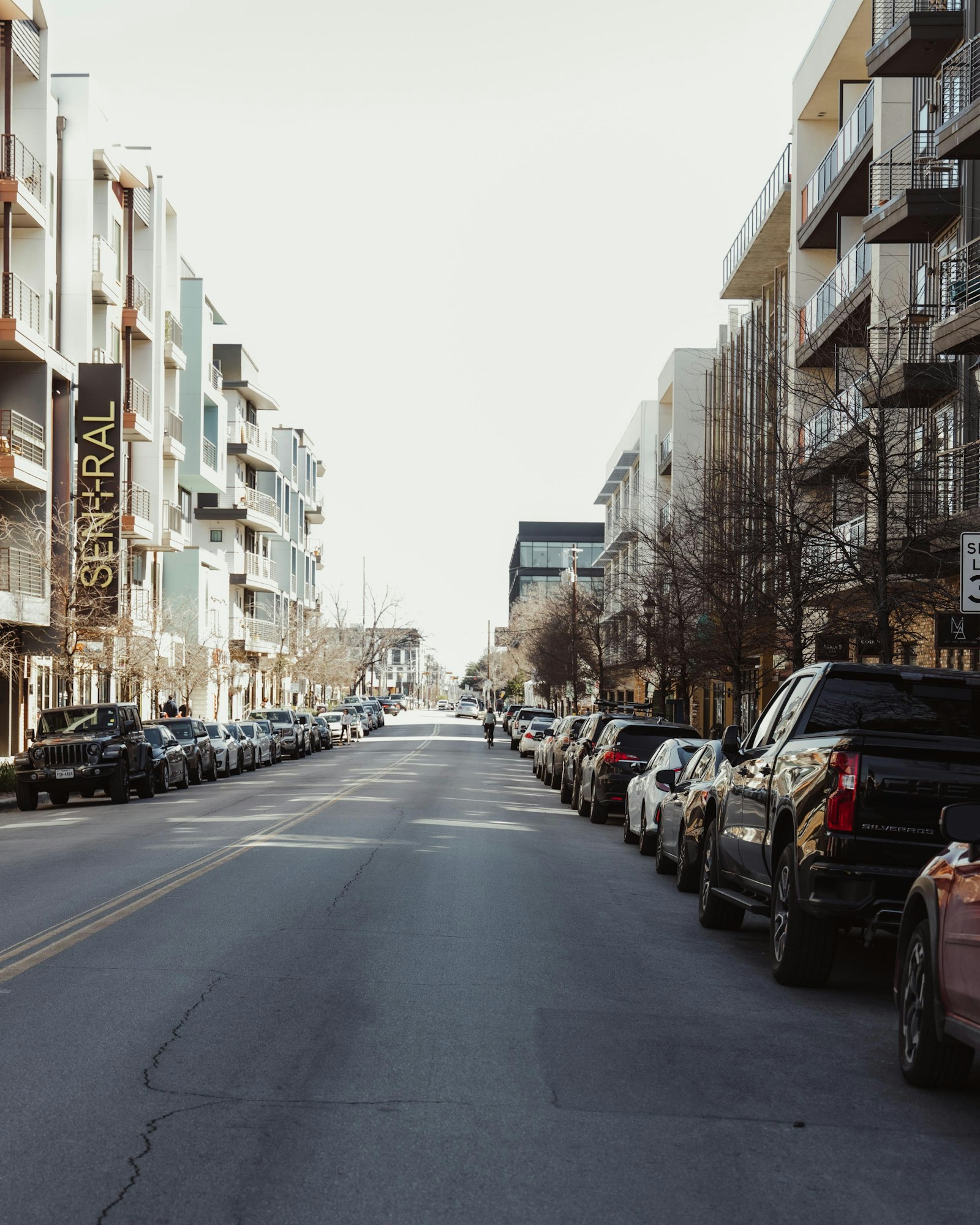 Calle larga con hileras de coches aparcados