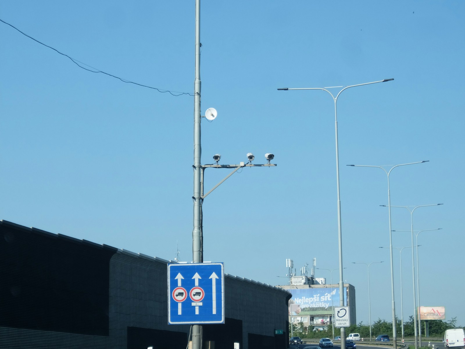 Cámaras de control de tráfico montadas en un poste junto a una señal azul