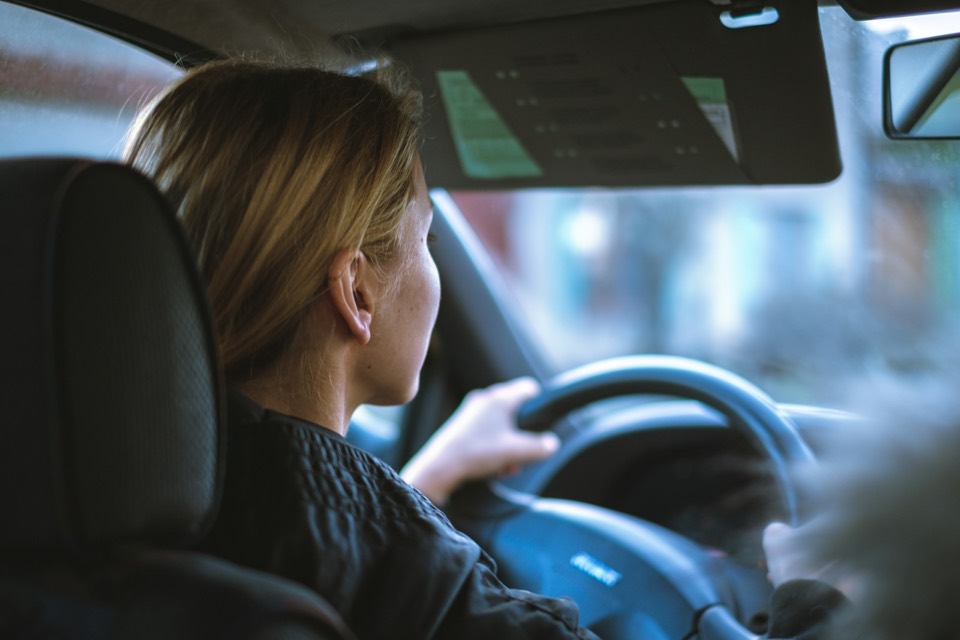 Conductora al volante de un coche con las manos en la dirección