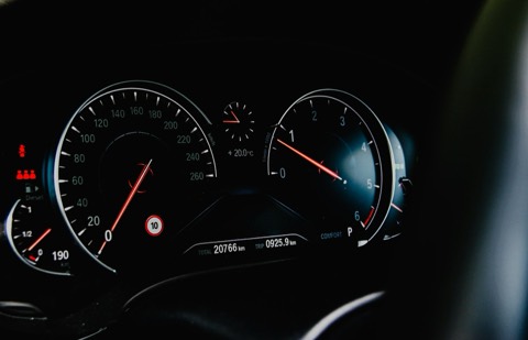Cuadro de instrumentos analógico de un coche con las agujas del tacómetro en primer plano