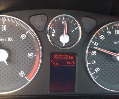 Cuadro de instrumentos de un coche mostrando 222.222 kilómetros en el odómetro