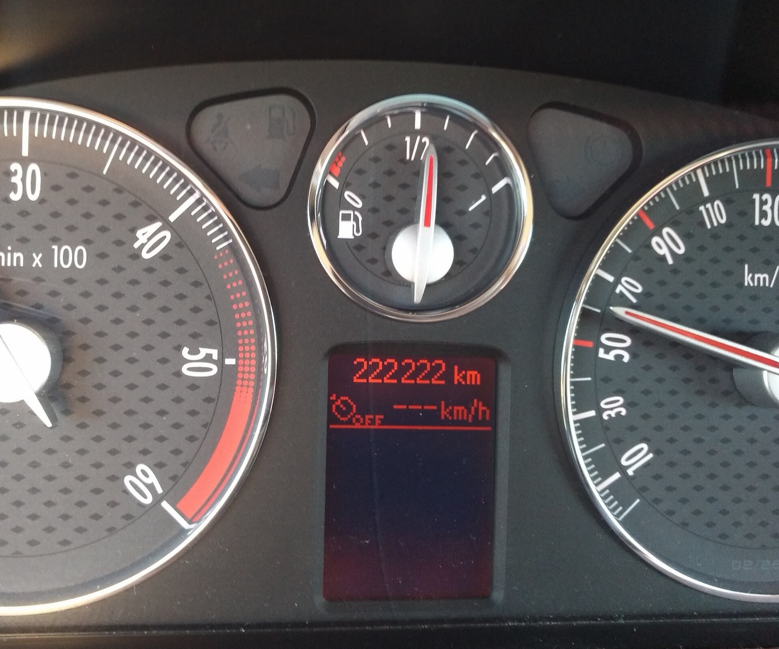 Cuadro de instrumentos de un coche mostrando 222.222 kilómetros en el odómetro