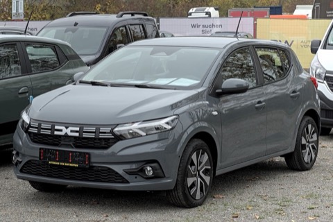 Dacia Sandero III gris de tres cuartos delantero aparcado en una explanada de concesionario