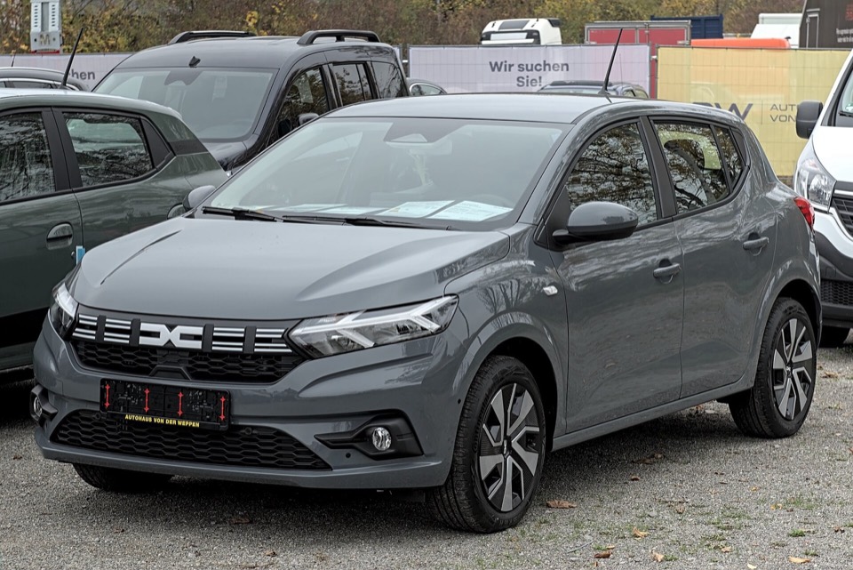 Dacia Sandero III gris de tres cuartos delantero aparcado en una explanada de concesionario