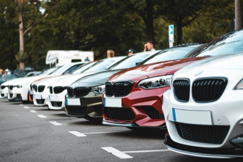 Hilera de coches de distintos colores aparcados en batería en un aparcamiento