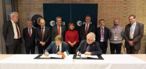 Dos personas firmando un contrato sobre una mesa