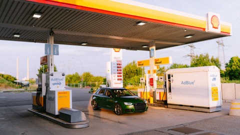Coche repostando en una gasolinera a plena luz del día