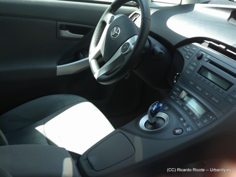 Puesto de conducción de un Toyota Prius con el selector de marchas azul característico del sistema híbrido