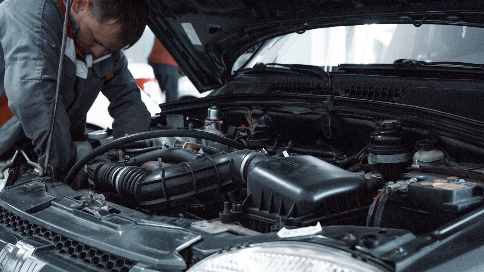 Mecánico inspeccionando el vano motor de un coche