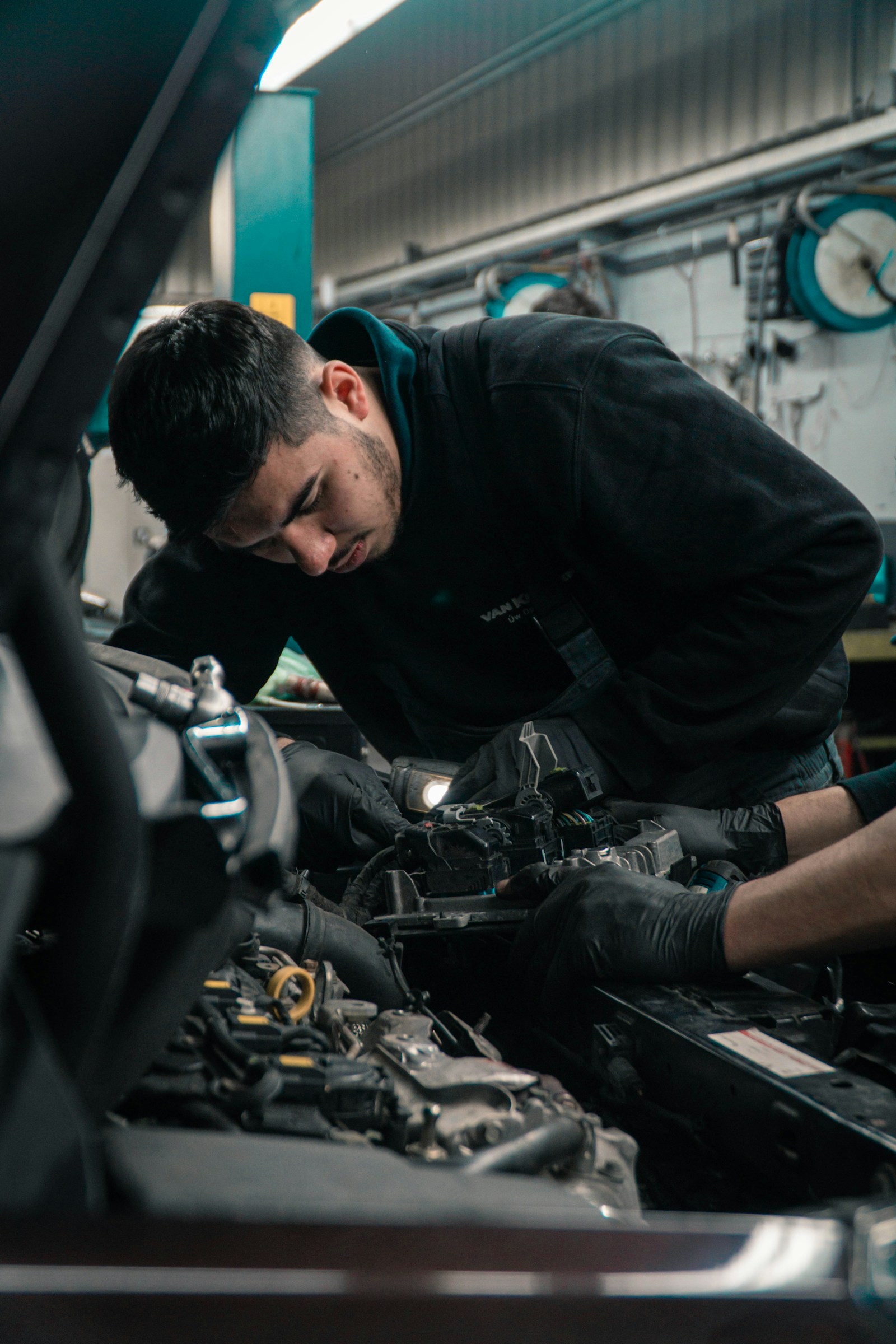 Mecánico revisando el motor con una lámpara de inspección