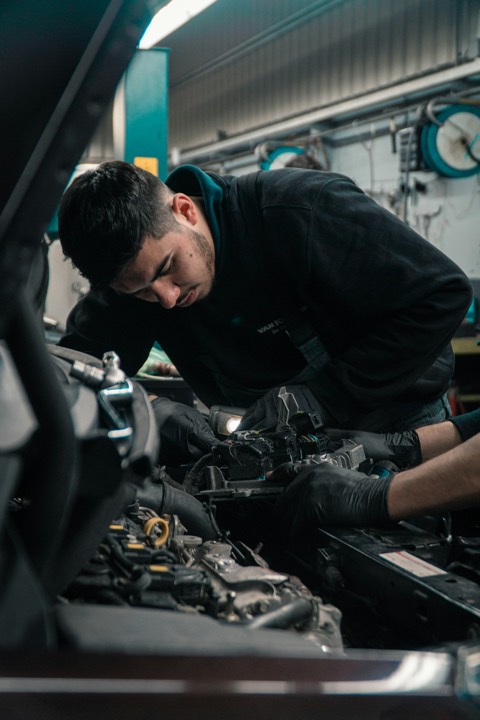 Mecánico trabajando en el vano motor de un coche