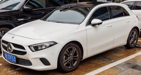 Mercedes Clase A W177 blanco aparcado en una calle en un día de lluvia