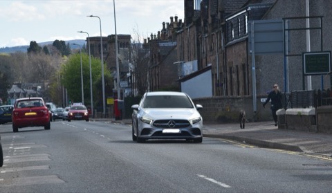 Mercedes Clase A W177 gris circulando de frente por una calle con edificios de piedra