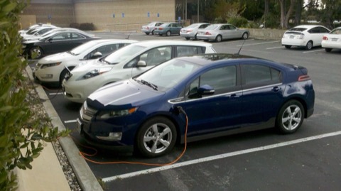 Un Nissan Leaf y un Chevrolet Volt cargando en un punto de recarga público