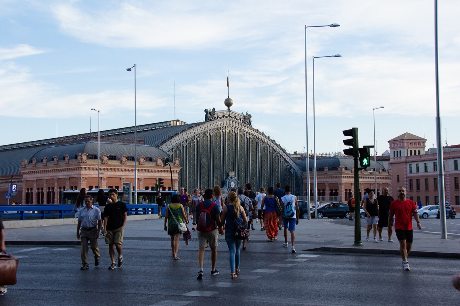 Peatones cruzando un paso de cebra frente a la estación de Atocha, en Madrid
