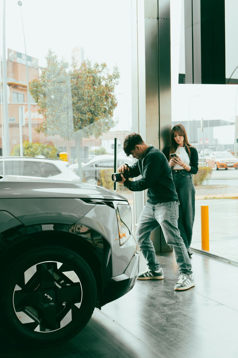 Dos personas conectando un coche eléctrico a un punto de recarga