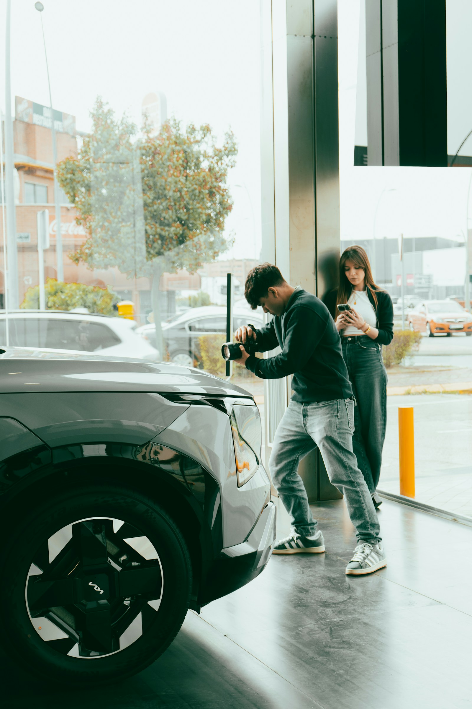 Dos personas conectando un coche eléctrico a un punto de recarga