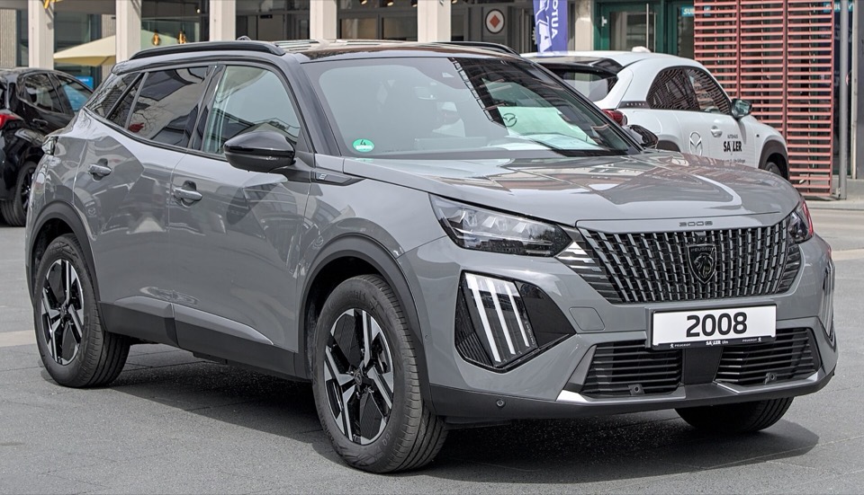 Peugeot e-2008 gris de tres cuartos delantero en un concesionario