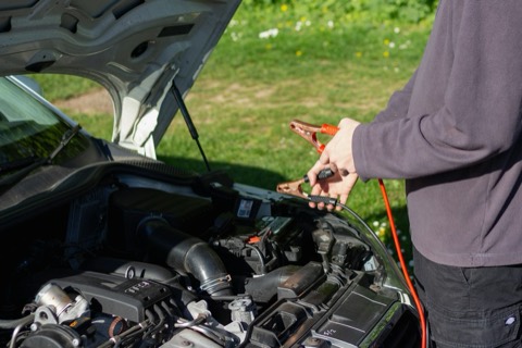 Pinzas de arranque conectadas a la batería de un coche