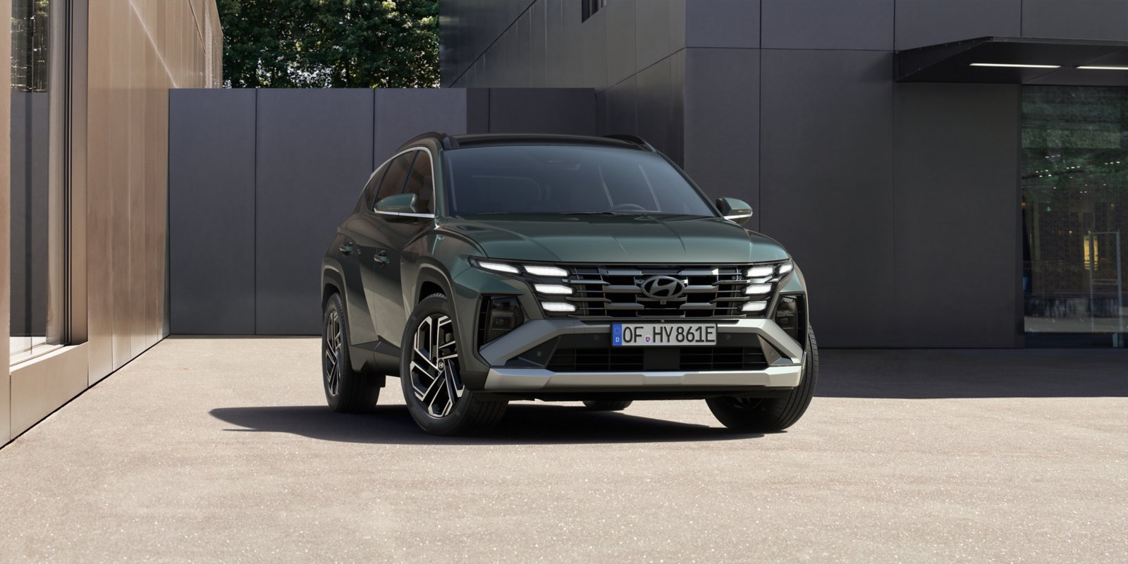 Hyundai Tucson de la generación actual, de frente, ante un edificio de hormigón