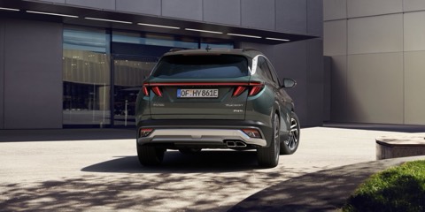 Hyundai Tucson verde de espaldas, aparcado ante un edificio