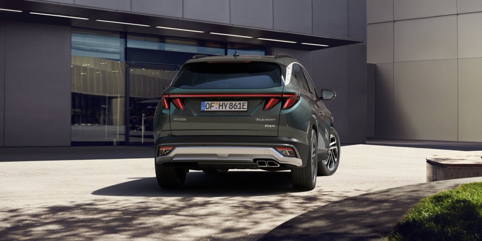 Hyundai Tucson verde de espaldas, aparcado ante un edificio