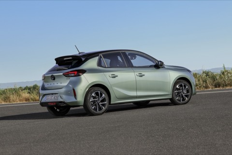 Opel Corsa verde de tres cuartos trasero, parado junto a la carretera