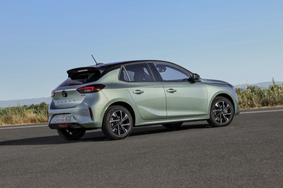 Opel Corsa verde de tres cuartos trasero, parado junto a la carretera