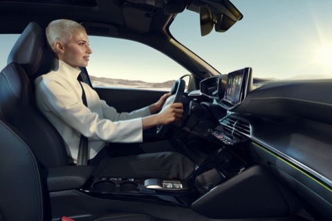 Conductora al volante del Peugeot 2008, con el i-Cockpit y la pantalla central