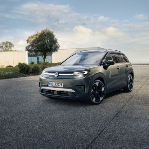 Volkswagen ID. Cross de serie en verde, de frente, aparcado ante un edificio moderno