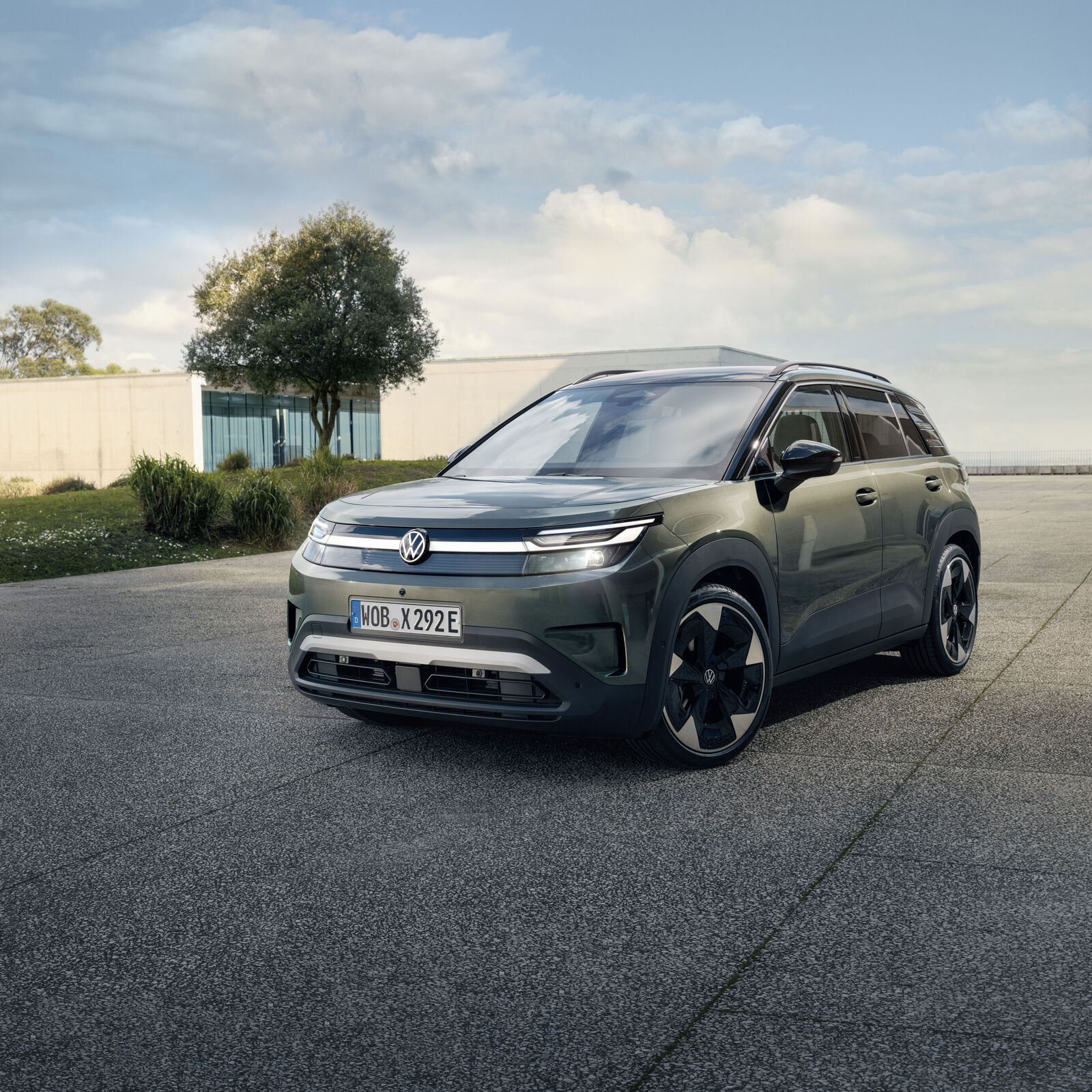 Volkswagen ID. Cross de serie en verde, de frente, aparcado ante un edificio moderno