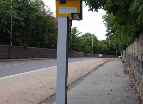 Radar fijo de velocidad instalado en un poste al borde de una carretera