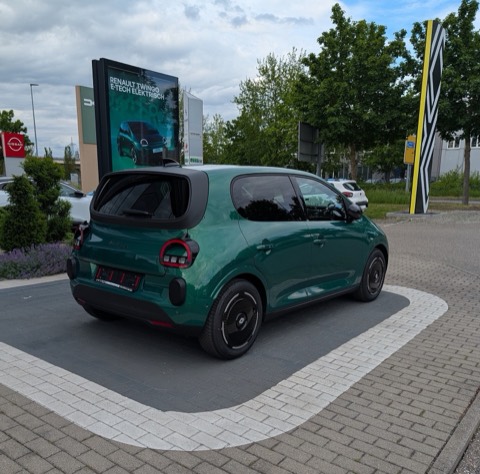 Renault Twingo E-Tech eléctrico verde visto de tres cuartos traseros en un concesionario