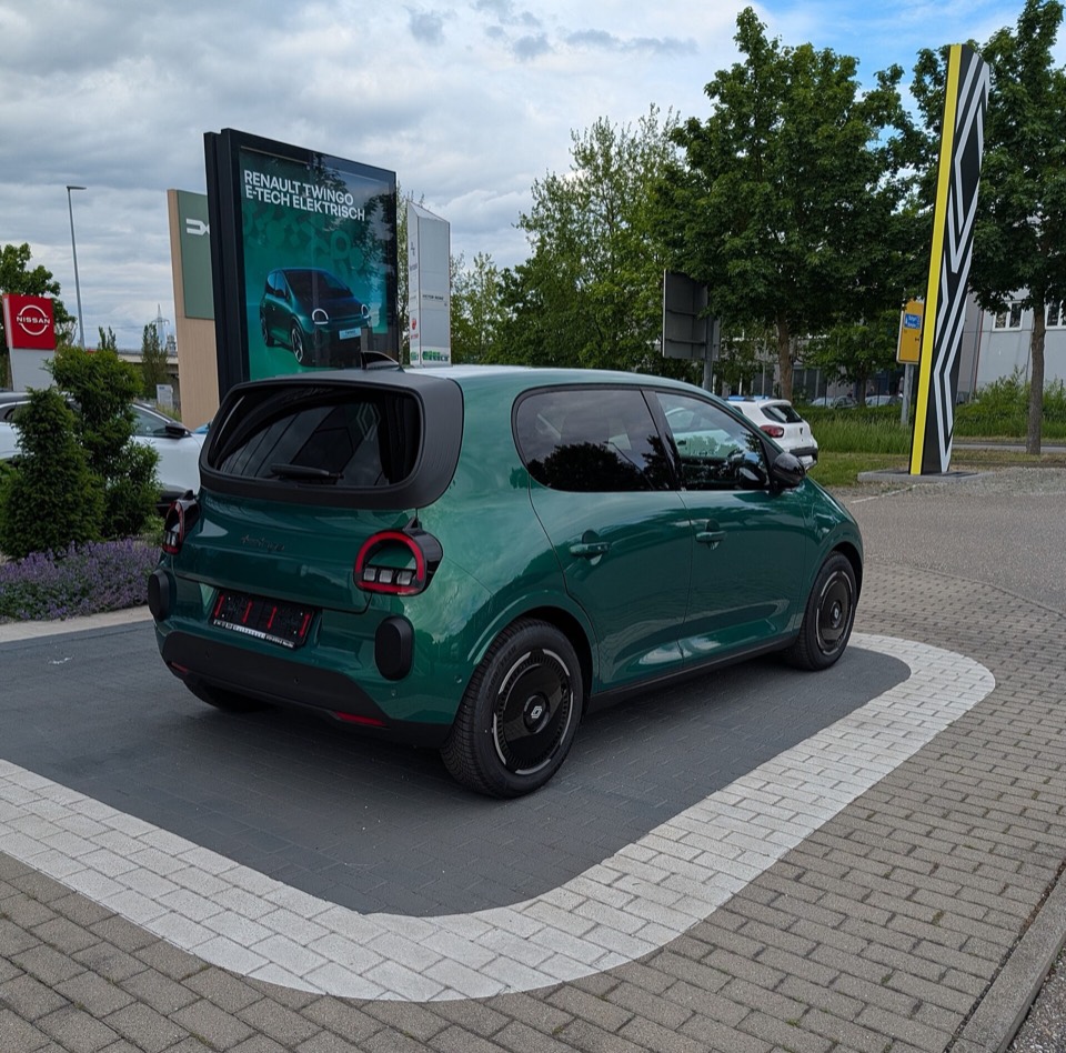 Renault Twingo E-Tech eléctrico verde visto de tres cuartos traseros en un concesionario