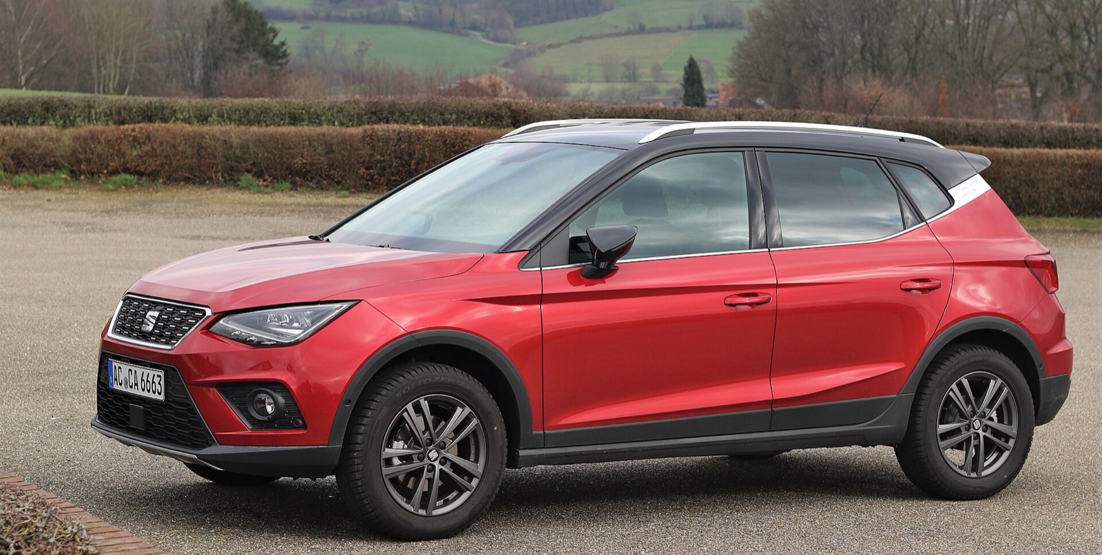 SEAT Arona rojo visto de perfil, donde se aprecia su mayor altura frente a un utilitario